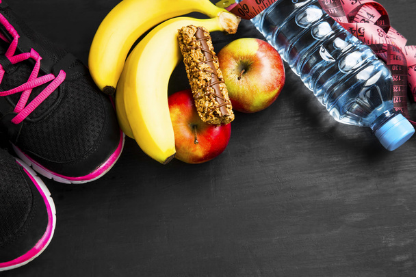 Estilo de vida saudável com itens esportivos, frutas e água
 - Foto, Imagem