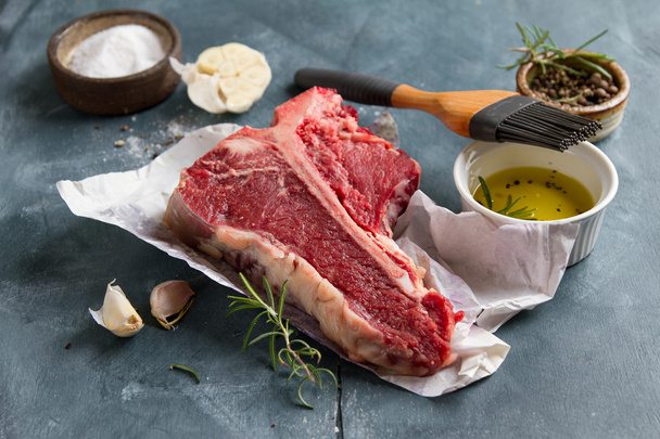 Thick raw T-bone steak with seasoning - Фото, зображення