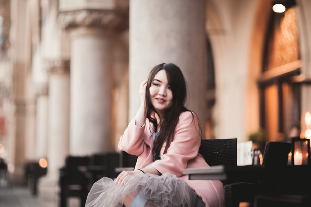 Beautiful Asian girl model in dress sitting at the old city background - Zdjęcie, obraz