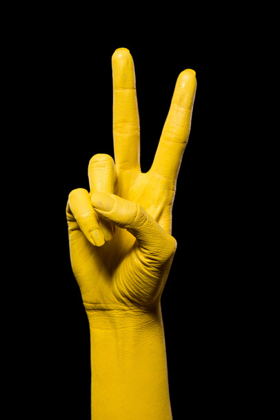 Mão amarela mostrando dois dedos
.  - Foto, Imagem