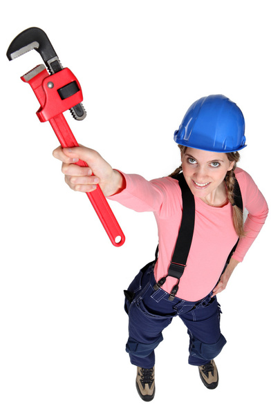 Tradeswoman holding up a pipe wrench - Фото, изображение