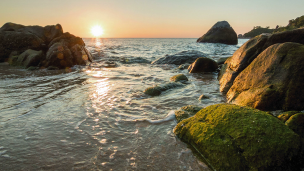 Zee zonsondergang op de rotsachtige kust - Video