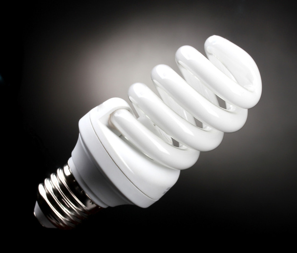 Energy saving lamp on black background - Foto, immagini