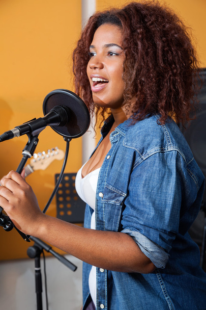 Miembro de la banda femenina cantando en el estudio de grabación
 - Foto, Imagen