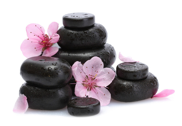 Spa stones with drops and pink sakura flowers isolated on white - Foto, imagen