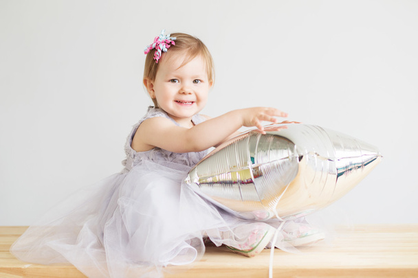 Πορτρέτο του ένα υπέροχο κοριτσάκι παίζει με ασημένιο αστέρι σχήμα - Φωτογραφία, εικόνα