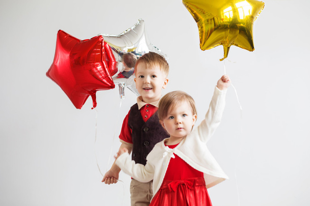白とカラフルな光沢のある箔風船で幸せな子供 - 写真・画像