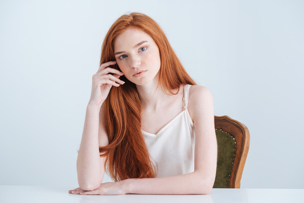 Charming redhead woman sitting at the table - Фото, зображення