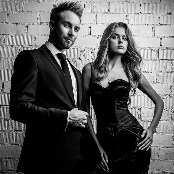 Portrait of young attractive couple posing studio dressed in black fashionable clothes. Black-white photo. - Foto, Imagem