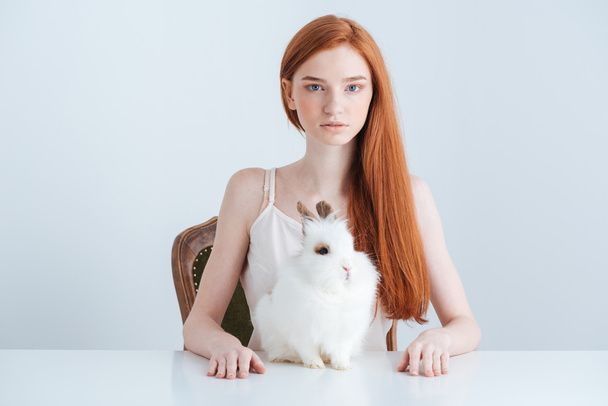Woman sitting at the table with rabbit - Фото, зображення