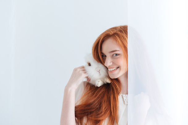 Happy redhead woman posing with rabbit - Фото, зображення