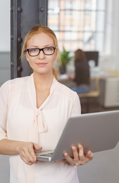 Young Businesswoman Holding Laptop in Office - Foto, imagen