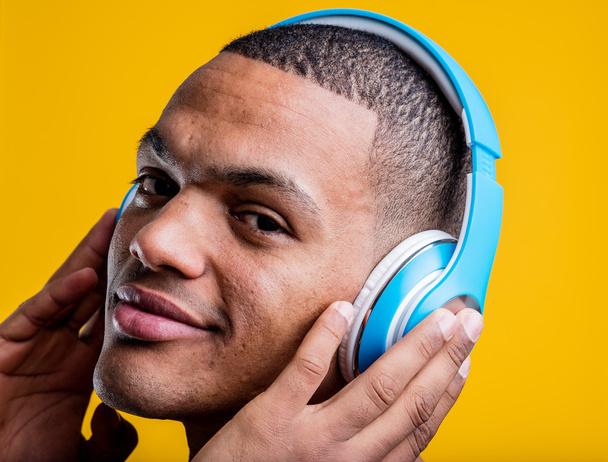 homem ouvindo música em seus fones de ouvido azuis
 - Foto, Imagem