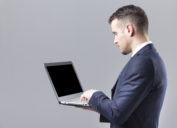 Young businessman using a laptop  - Фото, изображение