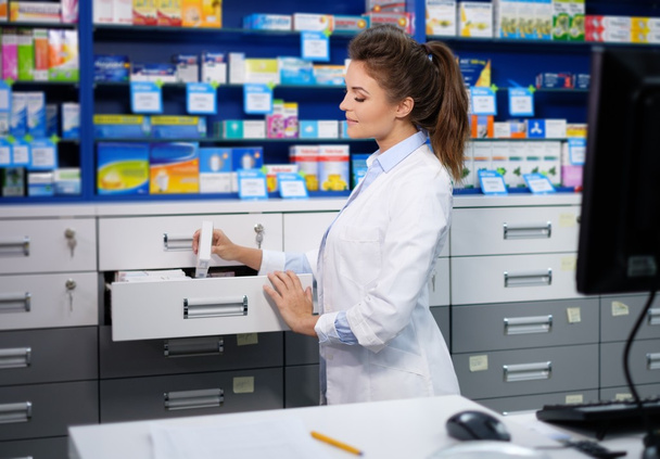 жінка фармацевт робить свою роботу в аптеці
. - Фото, зображення