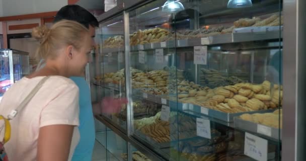 Couple choosing tasty cookies in the grocery - Кадры, видео