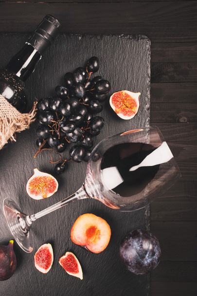 Food background with red wine, figs, grapes and cheese - Фото, изображение