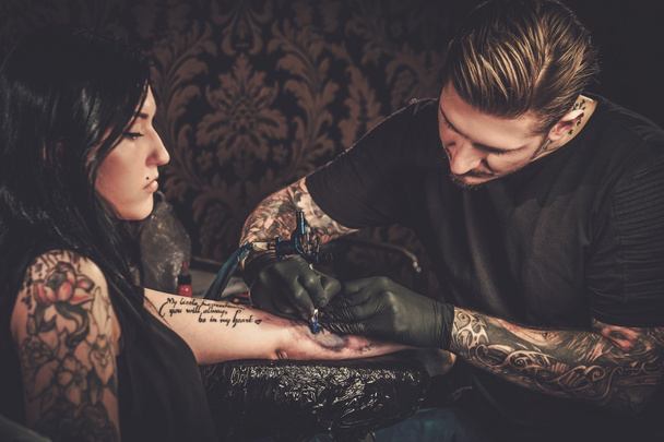 Профессиональный татуировщик делает татуировку
  - Фото, изображение