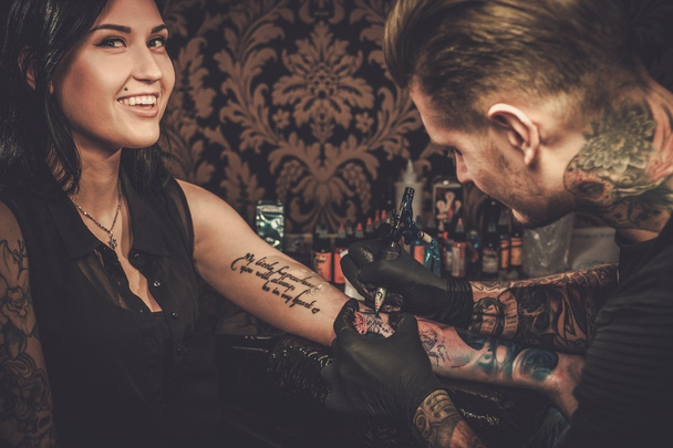 Artista profesional del tatuaje hace un tatuaje
  - Foto, imagen