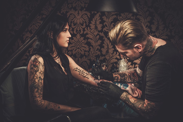 Professional tattoo artist makes a tattoo  - Photo, Image