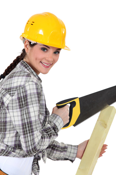 Woman sawing plank - Foto, afbeelding