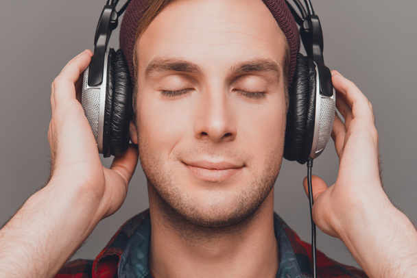 Close up portrait of relaxed man in head-phones listening music  - Foto, Bild