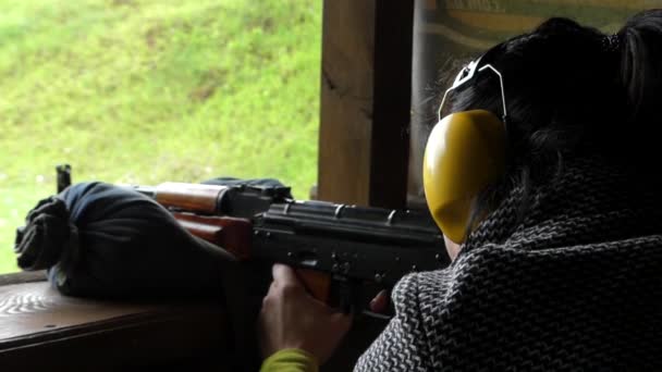 Mädchen schießt mit Maschinengewehr in Zeitlupe. - Filmmaterial, Video