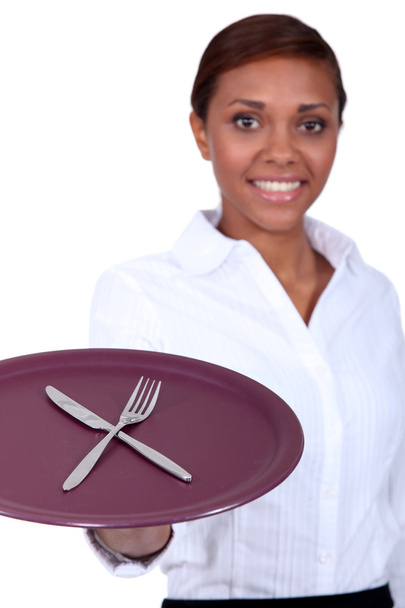 Waitress holding a plate with knife and fork - 写真・画像