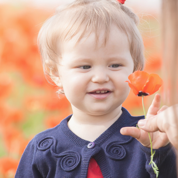 Funny child holding a balloon outdoor at poppy field - Φωτογραφία, εικόνα