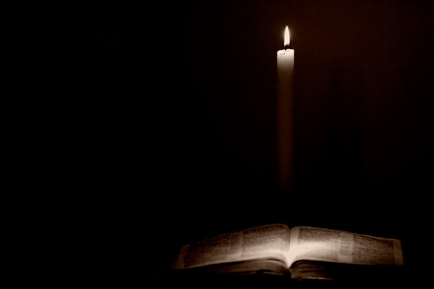 Holy Bible Lit by Candle Light - Vintage Style. - Photo, Image