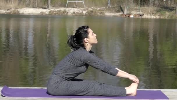 El profesor de yoga entrena su cuerpo. Estira las piernas
. - Metraje, vídeo