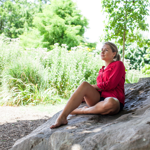 концепція відображення та дерева сумна молода жінка сидить на гігантському камені для літньої свіжості
 - Фото, зображення