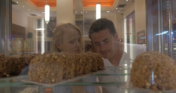 Muž a žena výběr dortů v cukrovinkách - Záběry, video