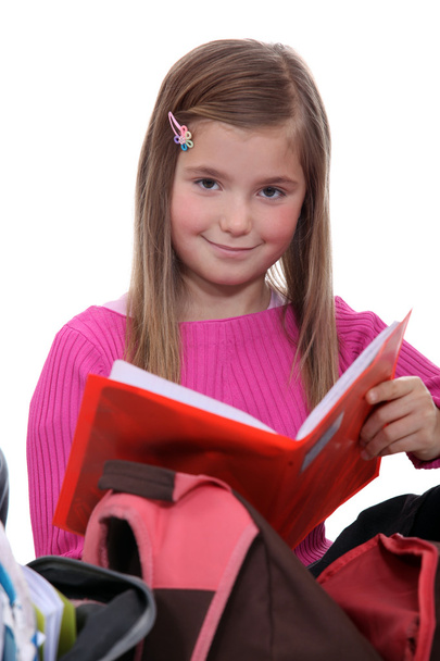 Schoolgirl removing book from backpack - Foto, Imagem