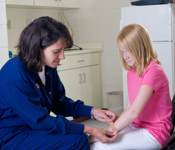 Nurse giving band aid to patient - Photo, Image