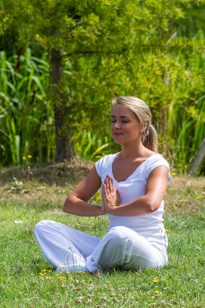 Meditation im Freien - Zen-20er blondes Mädchen, das sich selbst revitalisiert, Parkumgebung - Foto, Bild