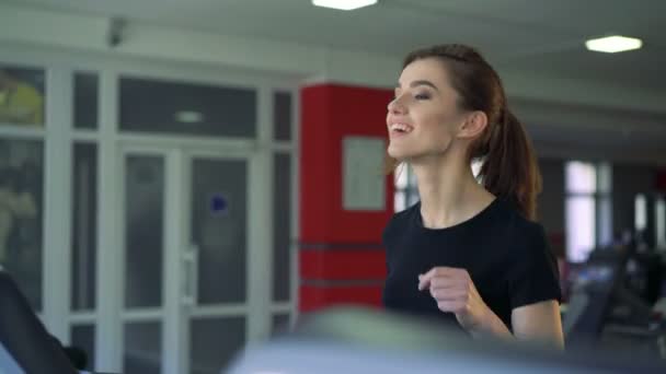 Beautiful girl on a treadmill - Materiał filmowy, wideo