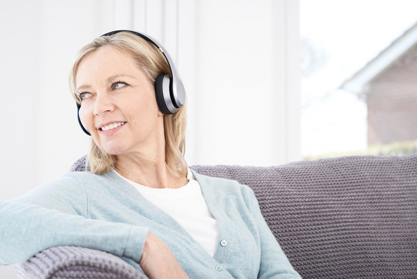 Mature Woman Listening To Music On Wireless Headphones - Fotografie, Obrázek