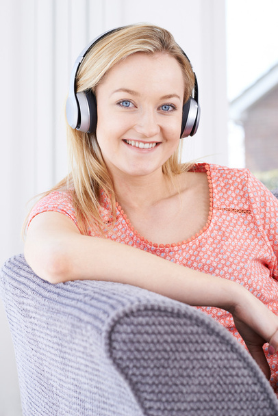 Young Woman Listening To Music On Wireless Headphones - Foto, afbeelding