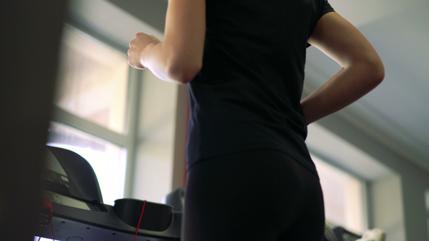 Close-up of a girl on a treadmill. 4k - Felvétel, videó