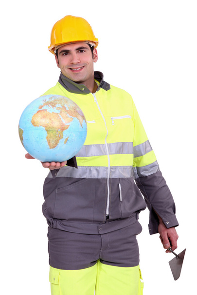 Builder holding a globe - Foto, afbeelding