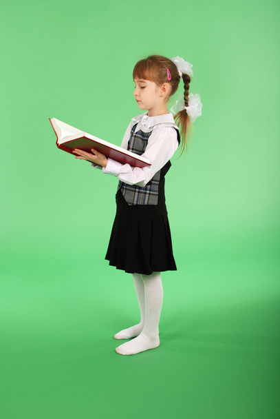 menina em uniforme escolar lendo um livro
 - Foto, Imagem