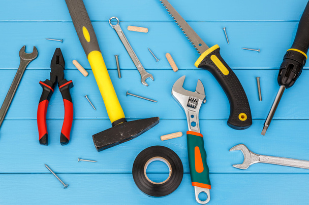 Straggly ferramentas de trabalho que colocam no fundo de madeira azul
. - Foto, Imagem