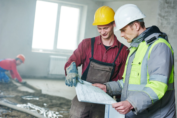 foreman builder and construction worker with blueprint in indoor apartment - Foto, imagen