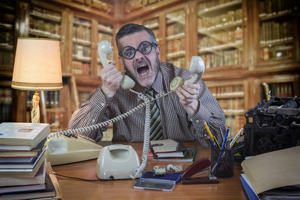 Empleado con gafas hablando por teléfono en la oficina en el
  - Foto, Imagen