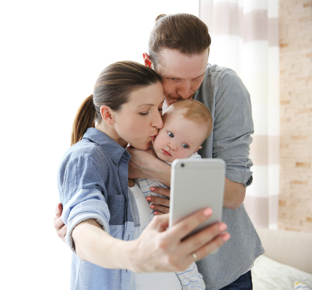 couple taking a selfie with baby - Фото, изображение