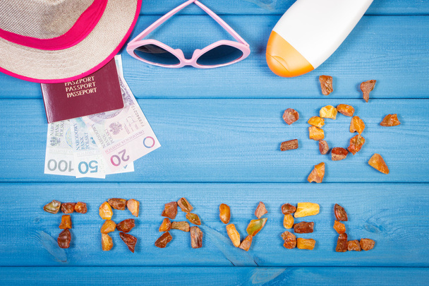 Word travel with shape of sun, sunglasses, sun lotion, straw hat, passport with polish money - Фото, изображение