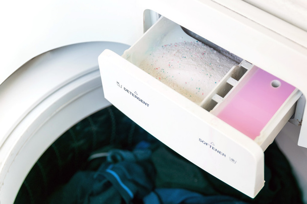 Миючий засіб і пом'якшувач тканини в пральній машині
. - Фото, зображення