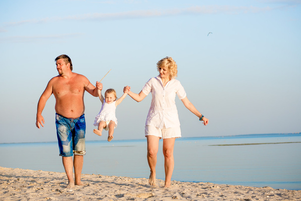 Семья играет на пляже
 - Фото, изображение