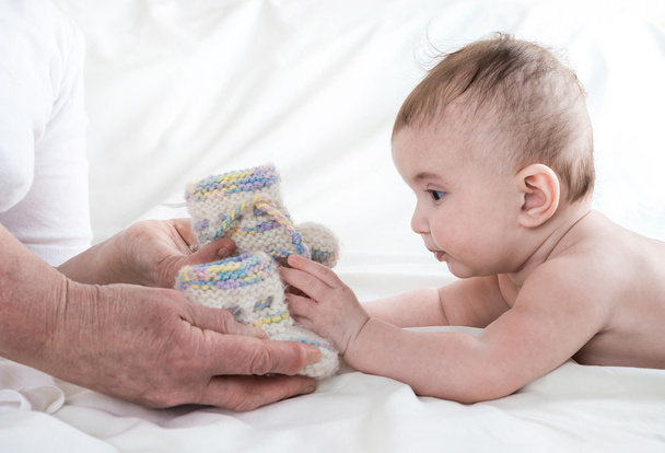  Grandmother knitted baby socks warm , caring for the child - Foto, Bild